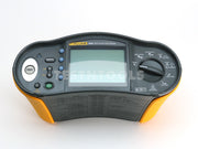 A Fluke 1662 Multifunction Tester device with a black and yellow plastic housing, featuring a central LCD screen, rotary dial, and various control buttons on a white background.
